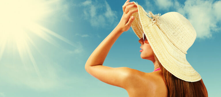 Fashionable woman with straw hat protects from sun